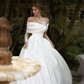 Elegant off-the-shoulder white tutu wedding dress with raglan sleeve long sheer sleeves and lace detailing