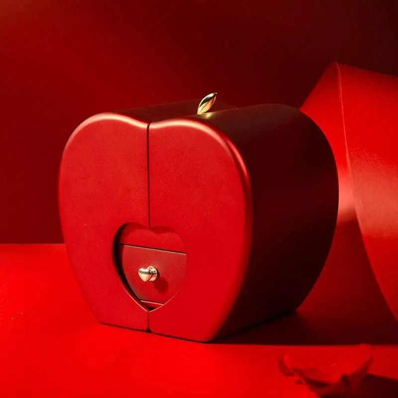 Red apple jewelry box in a heart shape with metallic clasp and small drawer featuring a heart cutout for eternal rose and clavicle chain storage