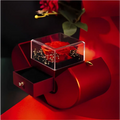Red apple jewelry box with burgundy velvet, featuring an eternal rose in a clear acrylic cube and a clavicle chain drawer