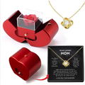 Red apple jewelry box with clear acrylic lid displaying an eternal rose and clavicle chain inside a red heart-shaped box