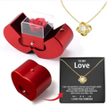 Red apple jewelry box with clear lid showcasing a preserved red eternal rose and a silver clavicle chain necklace inside