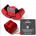 Red apple jewelry box with red metallic heart shape, clear acrylic lid, preserved eternal rose, and clavicle chain inside