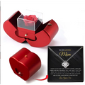 Red metallic apple jewelry box with clear acrylic insert holding an eternal rose and clavicle chain necklace