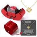 Red apple jewelry box with clear acrylic lid revealing an eternal rose and clavicle chain necklace inside