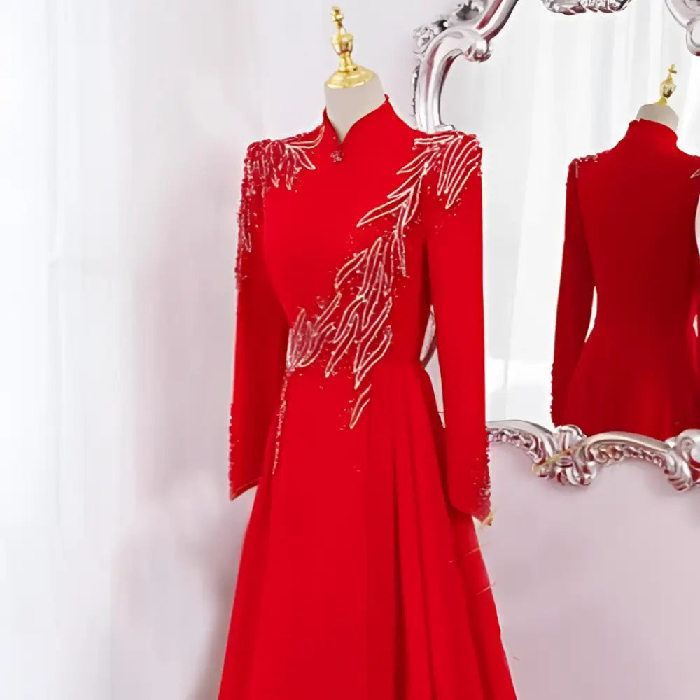 A vibrant red beaded long sleeve formal evening gown with intricate gold beading displayed on a mannequin