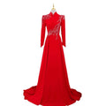 A vibrant red beaded long sleeve formal evening gown with floor-length design and intricate white leaf patterns