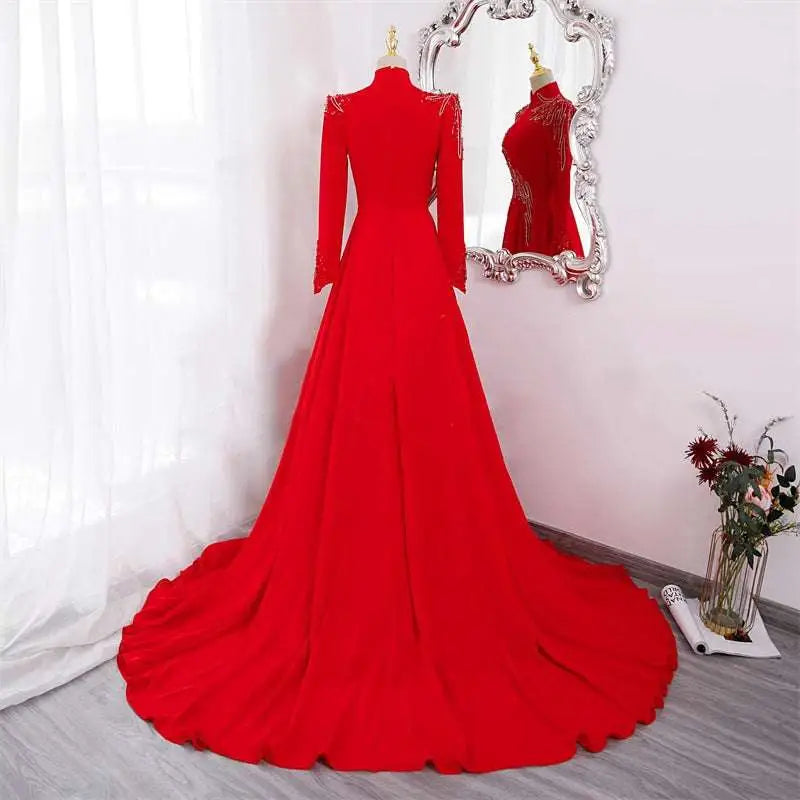 Red beaded long sleeve formal evening gown in vibrant red with high neckline and intricate shoulder detailing