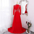 A vibrant red beaded long sleeve formal evening gown with intricate silver beading on shoulders and waistline