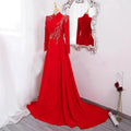 A red beaded long sleeve formal evening gown with intricate gold embroidery on shoulders and bodice