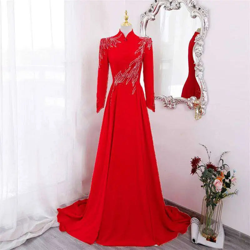 A vibrant red beaded long sleeve formal evening gown with intricate silver beading on shoulders and waistline