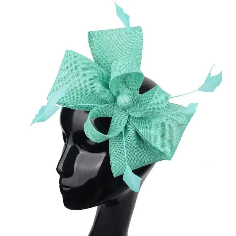 A mint green ladies banquet ball fascinator featuring a large textured bow and delicate feather accents