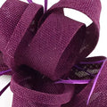 A deep purple woven ladies banquet ball fascinator with textured fabric and subtle shimmering accents