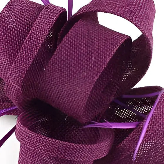 A deep purple woven ladies banquet ball fascinator with textured fabric and subtle shimmering accents