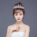 A sparkling silver crystal alloy crown wedding accessory with intricate details and a regal pointed crown design