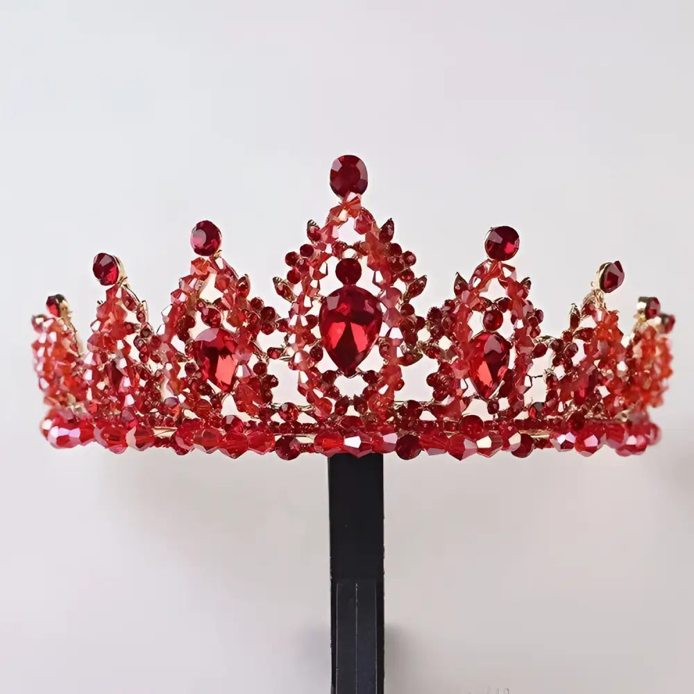 A sparkling red crystal alloy crown wedding accessory with intricate crystals and a central teardrop gemstone