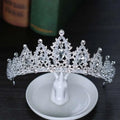 A sparkling silver crystal alloy crown wedding accessory with intricate embellishments and a central teardrop gemstone