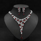 Elegant red crystal leaf zircon necklace set with v-shaped design in silver-toned metal featuring matching earrings