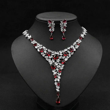 Elegant red crystal leaf zircon necklace set with v-shaped design in silver-toned metal featuring matching earrings