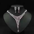 Elegant pink and clear crystal zircon necklace set with v-shaped design featuring square-cut stones and teardrop pendants