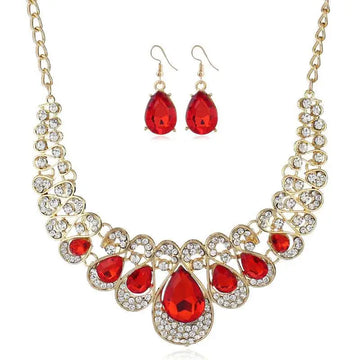 Gold-toned necklace featuring a bold red crystal teardrop centerpiece with clear crystals and matching chain in american jewelry fashion