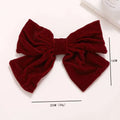 A plush deep red velvet red flannel big bow spring clip accessory with a subtle glittery sheen for spring styling