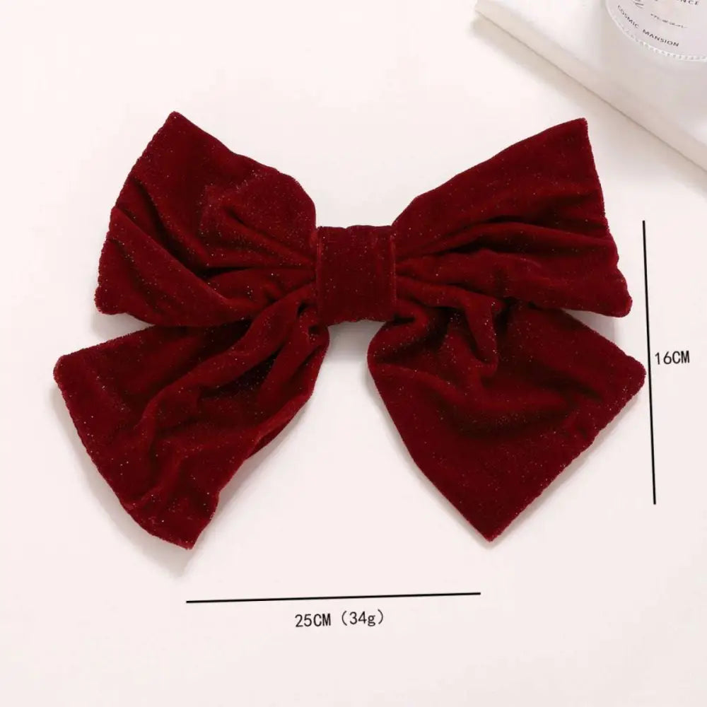 A plush deep red velvet red flannel big bow spring clip accessory with a subtle glittery sheen for spring styling