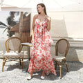 A flowing tiered maxi fashion simple dress in vibrant coral and white with red floral ruffled details and spaghetti straps