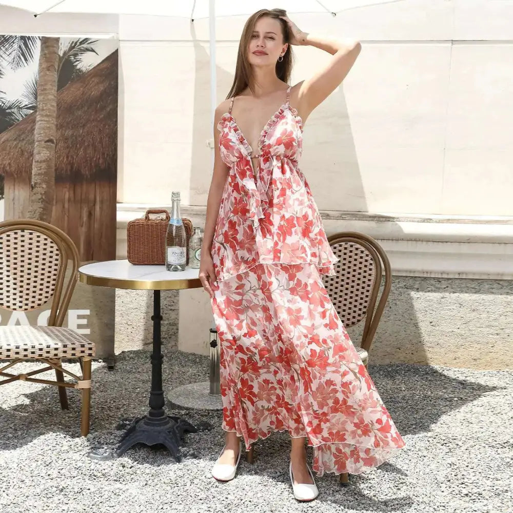 A flowing tiered maxi fashion simple dress in soft pink and coral with red floral ruffled bodice and layered skirt