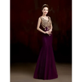 A woman wears an elegant deep purple red gold beaded fish tail banquet evening dress with intricate gold embroidery