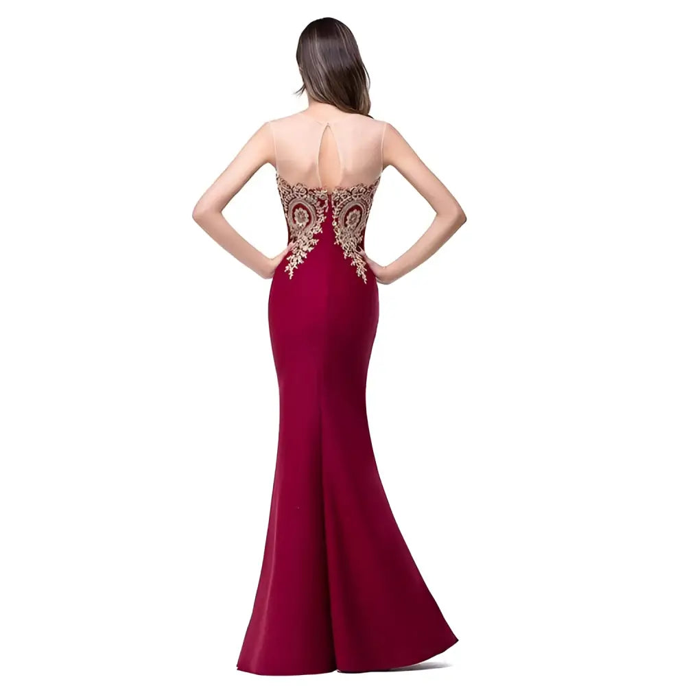 Back view of a deep red gold beaded fishtail skirt evening gown with sheer back and intricate gold lace waist detailing