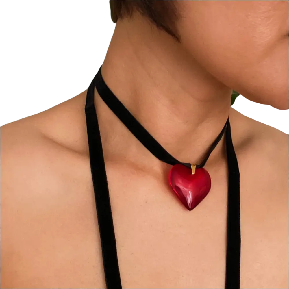A glossy red heart pendant on a black velvet choker black sash necklace in red black sash style