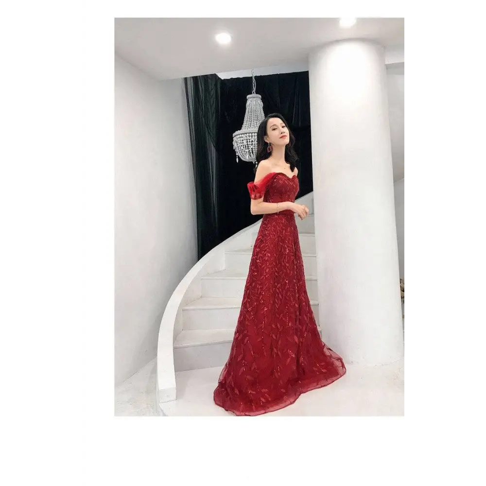 A shimmering red off-the-shoulder lace slim slimming bridal evening dress with delicate leaf patterns and sheer sleeves