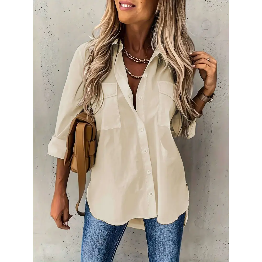 Beige loose long sleeve button down shirt with sleeve lapel button and two chest pockets with rolled-up sleeves