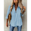 Light blue loose long sleeve shirt with sleeve lapel button and two chest pockets in a relaxed fit design