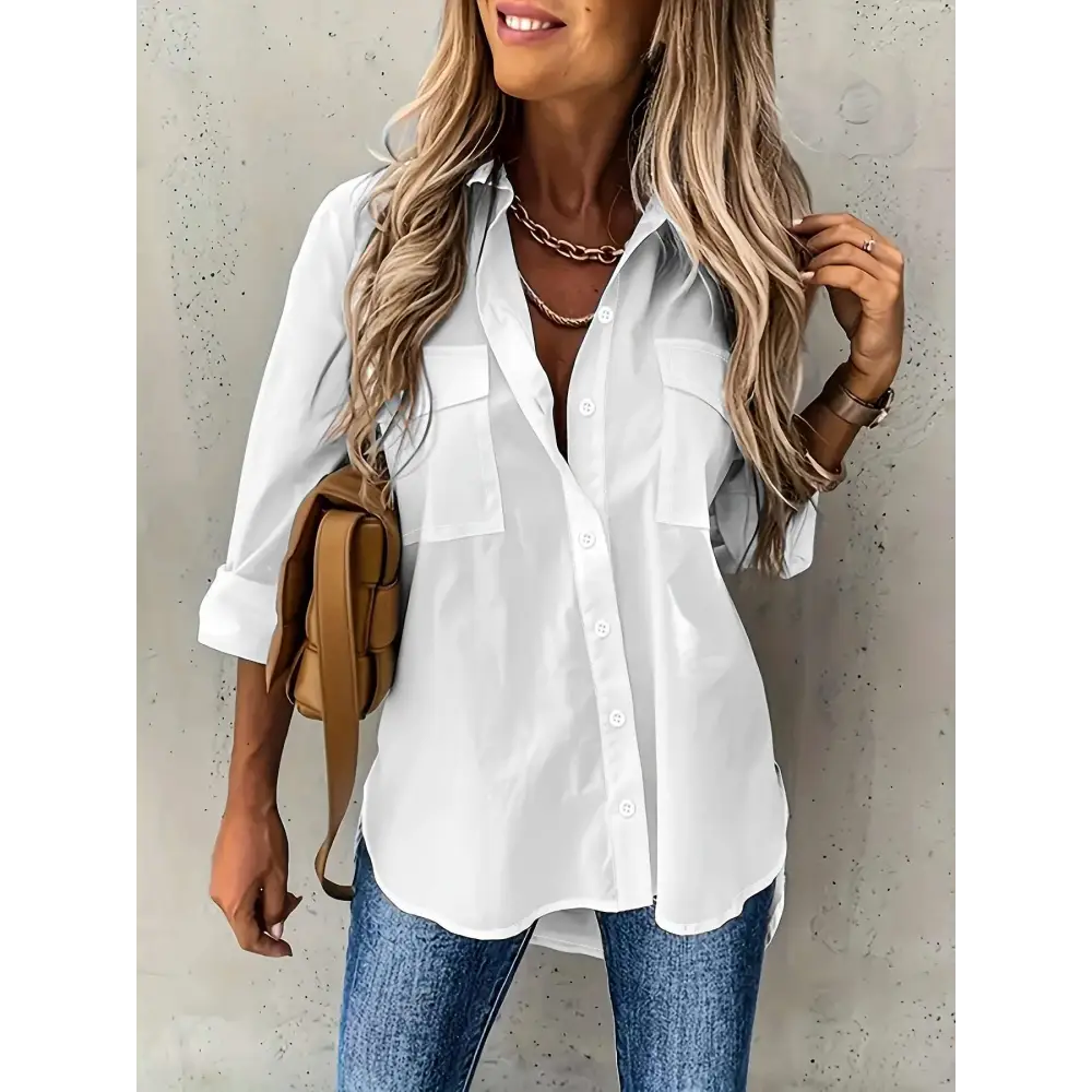 White loose long sleeve button down shirt with sleeve lapel button and two chest pockets with rolled-up sleeves