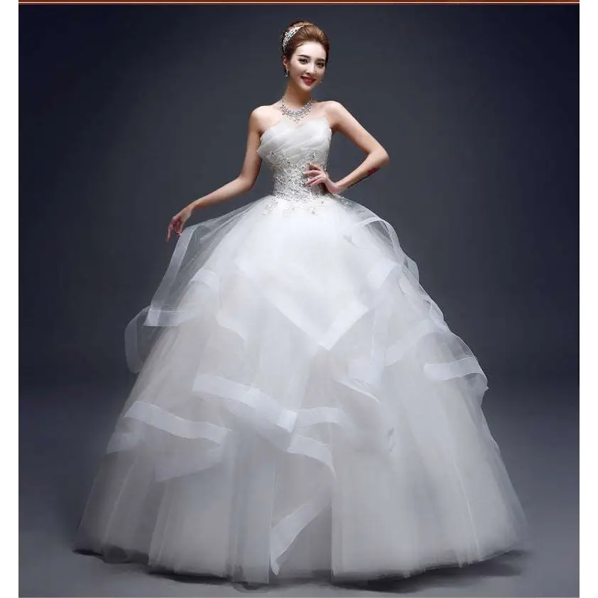 A strapless white wedding gown with beaded bodice and layered tulle skirt suited for one-shoulder wedding dresses