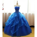 A royal blue strapless ball gown with a beaded bodice and layered tulle skirt in a one-shoulder wedding dress style