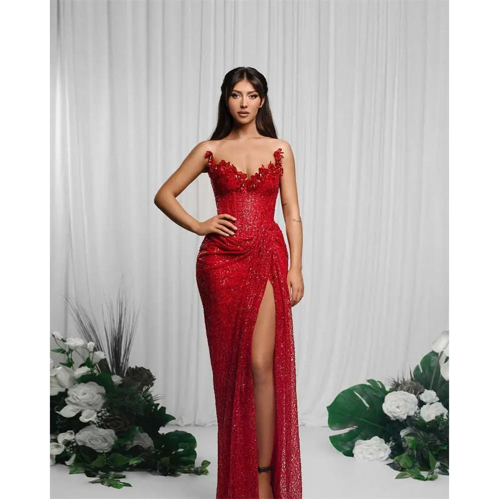 A shimmering red paillette tube high slit sequin gown with intricate floral embellishments at the neckline and side slit
