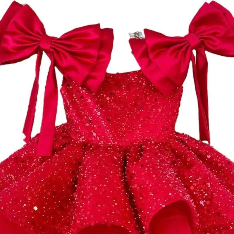 A vibrant red princess dress with sequins featuring tulle tutu and large bow sleeves at the shoulders