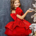 A vibrant princess dress red with a tulle tutu, large velvet bow sleeves, and layered ruffles