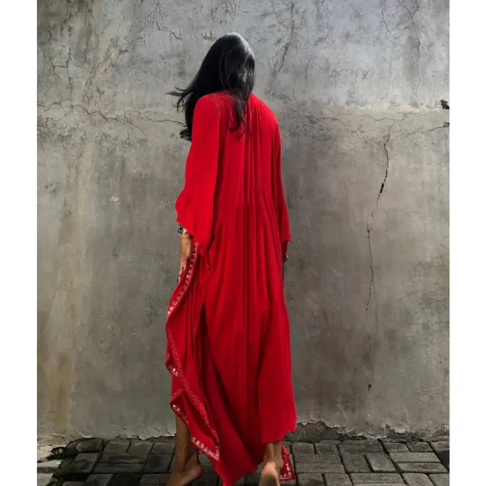 A flowing red rayon embroidered holiday sun protection cardigan with intricate white embroidery on hemline and sleeves