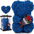 A plush blue rose bear with a red rose and dried flowers in its arm beside a clear eternal flower gift box