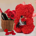 A red rose bear crafted from artificial flowers with a soft texture holding a small bouquet in an eternal flower gift box