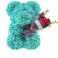 A turquoise rose bear figurine holding a bouquet of red roses wrapped in cellophane with a maroon ribbon eternal flower gift