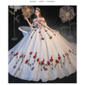 A white off-the-shoulder wedding gown with red rose embroidery and temperament bride bra trailing on a voluminous tulle skirt