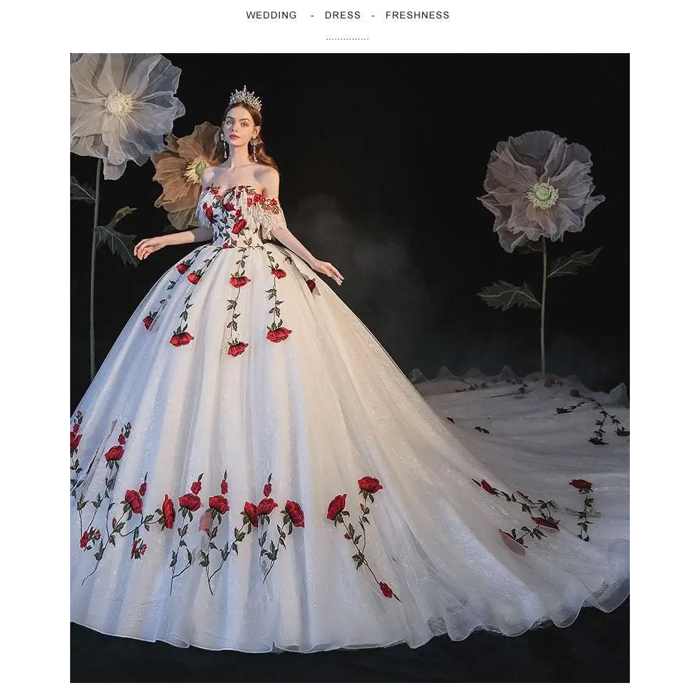 A flowing white wedding gown with red rose embroidery and lace detailing featuring temperament bride bra trailing design