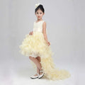 Ivory lace wedding flower girl dress with fitted bodice and voluminous ruffled skirt with asymmetrical train