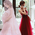 A flowing red satin engagement suspender evening dress with a fitted bodice and floral embellishments on tulle