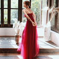 A flowing red satin engagement suspender evening dress with thin spaghetti straps and a fitted bodice