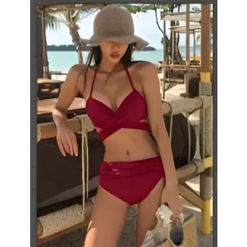 Red split bikini solid color swimsuit in two-piece design with halter neckline and matching bottoms for swimwear use